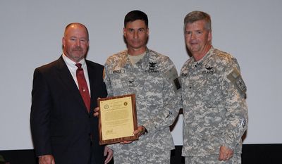 This handout photo provided by the US Army, taken in Jan. 2010, shows retired Army Col. Bert Vergez, center, receiving his charter to manage the Project Office for Non-Standard Rotary Wing Aircraft (NSRWA), established in January 2010, from the Program Executive Officer for Aviation, now Maj. Gen. William Crosby, right, and Randy Harkins, former deputy project manager NSRWA. The Justice Department is building a corruption case against a flamboyant Wall Street financier who won millions of dollars in military contracts and then hired the Army officer who steered the money her way.  Interviews and documents obtained by The Associated Press portray entrepreneur Lynn Tilton and Col. Bert Vergez as being in unusually close contact for more than a year before Vergez retired from the Army in late 2012. Among the allegations is that Vergez provided Tilton with details about upcoming contracts to give her company, MD Helicopters of Mesa, Ariz., an advantage over the competition.  (AP Photo/US Army)