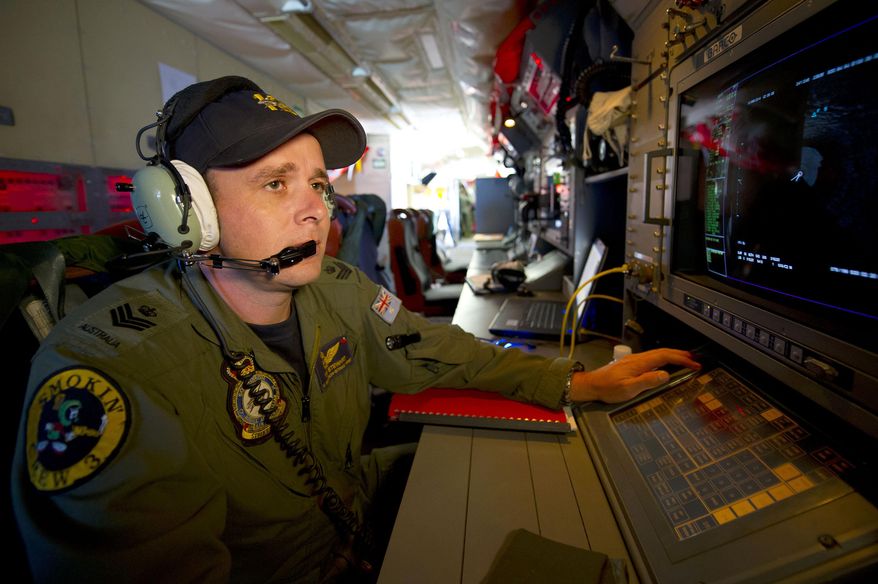 In this Wednesday, March 19, 2014 photo released by the Australia Defence Department, Royal Australian Air Force Airborne Electronics Analyst, Flight Sgt. Tom Stewart from 10 Squadron, on board an AP-3C Orion watches a radar screen over the Southern Indian Ocean off the Western Australian coast during a search operation for the missing Malaysia Airlines flight MH370. Australian Prime Minister Tony Abbott said Thursday that two objects possibly related to the missing flight have been spotted on satellite imagery in the Indian Ocean and an air force aircraft was diverted to the area to try to locate them. (AP Photo/Australia Defence Department, Hamish Paterson)