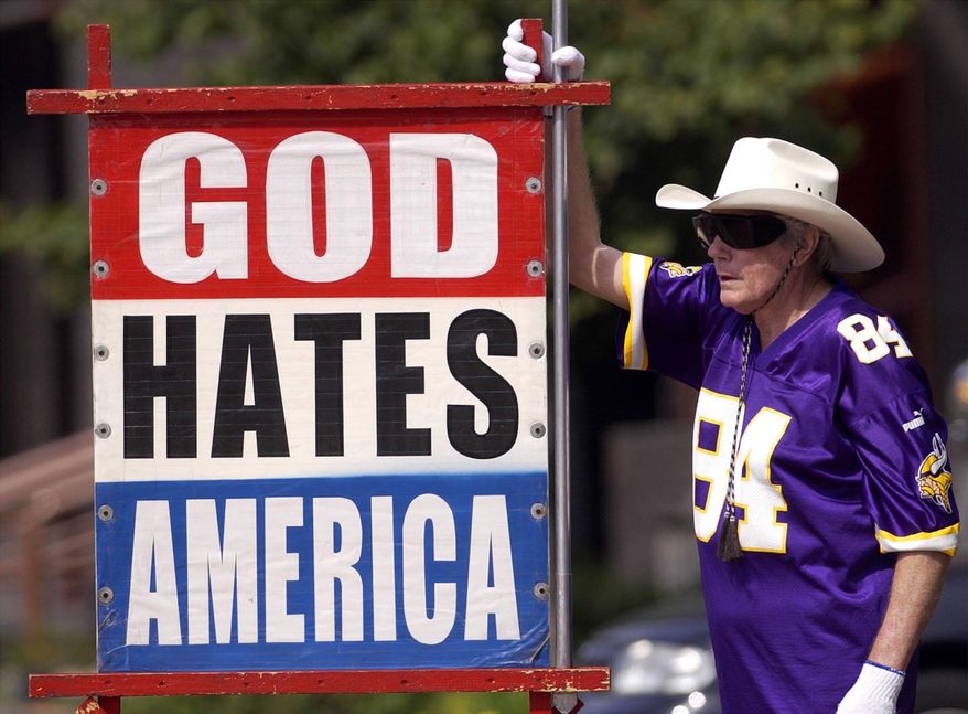 This file photo shows Fred Phelps Sr. displays one of his many infamous protest signs. Phelps, the fiery founder of the Westboro Baptist Church, a small Kansas church, who drew international condemnation for outrageous and hate-filled protests that blamed almost everything, including the deaths of AIDS victims and U.S. soldiers, on America's tolerance for gay people, has died the family said Thursday, March 20, 2014. He was 84. (AP Photo/The Topeka Capital Journal)