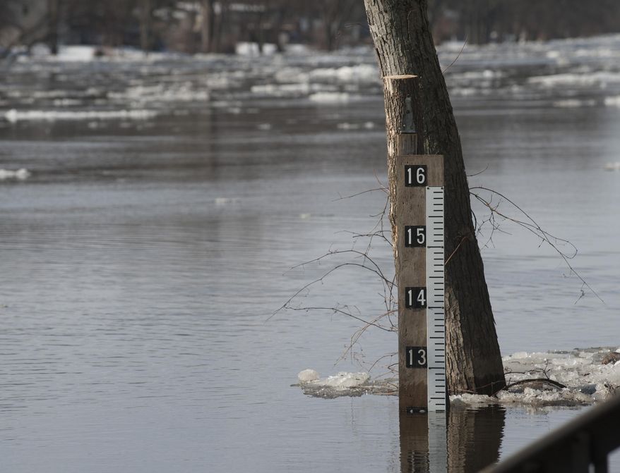 A measuring stick shows an unofficial height of the rising Grand River as it approaches homes on Abrigador Trail in Comstock Park, Mich., Thursday, March 20, 2014. A flood watch is in effect for the Grand River around Grand Rapids due to ice jams along the waterway. The National Weather Service reports jams are confirmed in at least two areas, with chunks of ice about 8 inches thick in places. (AP Photo/The Grand Rapids Press, Chris Clark) ALL LOCAL TV OUT; LOCAL TV INTERNET OUT