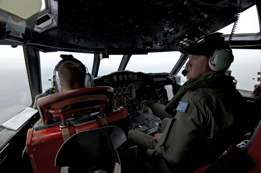 This Wednesday, March 19, 2014 photo released by the Australia Defence Department, shows Royal Australian Air Force Flight Engineer, Warrant Officer Ron Day from 10 Squadron, on board an AP-3C Orion over the Southern Indian Ocean off the Western Australian coast during a search operation for the missing Malaysian Airlines flight MH370. Australian Prime Minister Tony Abbott said Thursday that two objects possibly related to the missing flight have been spotted on satellite imagery in the Indian Ocean and an air force aircraft was diverted to the area to try to locate them. (AP Photo/Australia Defence Department, Hamish Paterson)