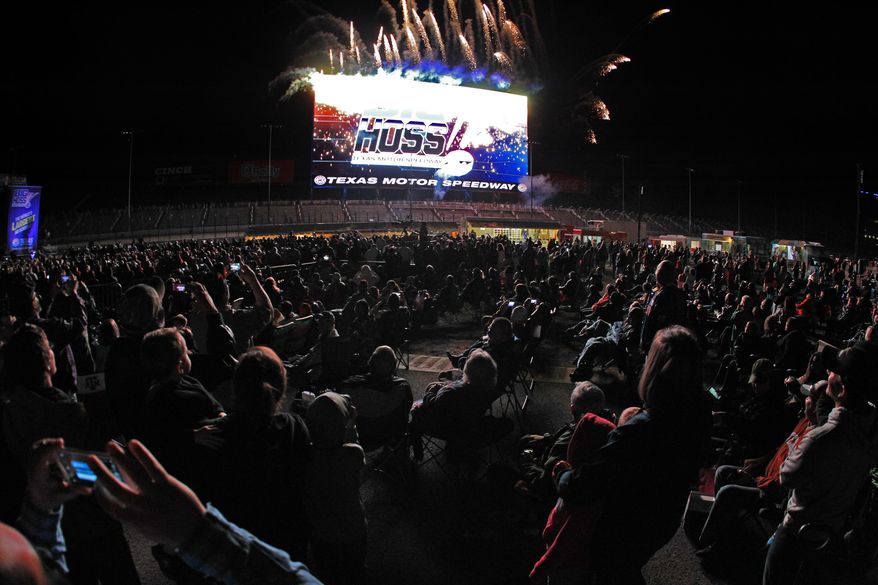 Fireworks light up near a high-definition video board that was unveiled Wednesday, March 19, 2014, at Texas Motor Speedway in Fort Worth, Texas. The screen is 218 feet wide and about 95 feet high. It is about 125 feet above ground level in the middle of the backstretch at the 1 1/2-mile track. (AP Photo/Fort Worth Star Telegram, Paul Moseley) MAGS OUT (FORT WORTH WEEKLY, 360 WEST); INTERNET OUT