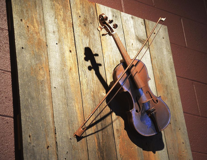 In this March 4, 2014 photo, a copper fiddle is seen on the wall in the bar and tasting area at the Copper Fiddle Distillery in Lake Zurich, Ill., where small-batch bourbon and other spirits are produced. Craft distillery licenses have about doubled in Illinois in the past year, and Copper Fiddle Distillery's debut in is the latest example of the industry's expansion. (AP Photo/Daily Herald, Bob Chwedyk) MANDATORY CREDIT, MAGS OUT