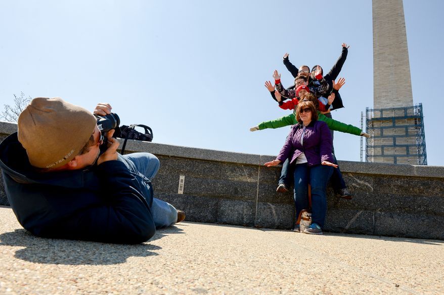 The Lund family from Wisconsin poses together in front of the Washington Monument, which is set to reopen in May, Washington, D.C., Thursday, March 20, 2014. The monument has been closed since 2011 for earthquake damage repairs. (Andrew Harnik/The Washington Times)