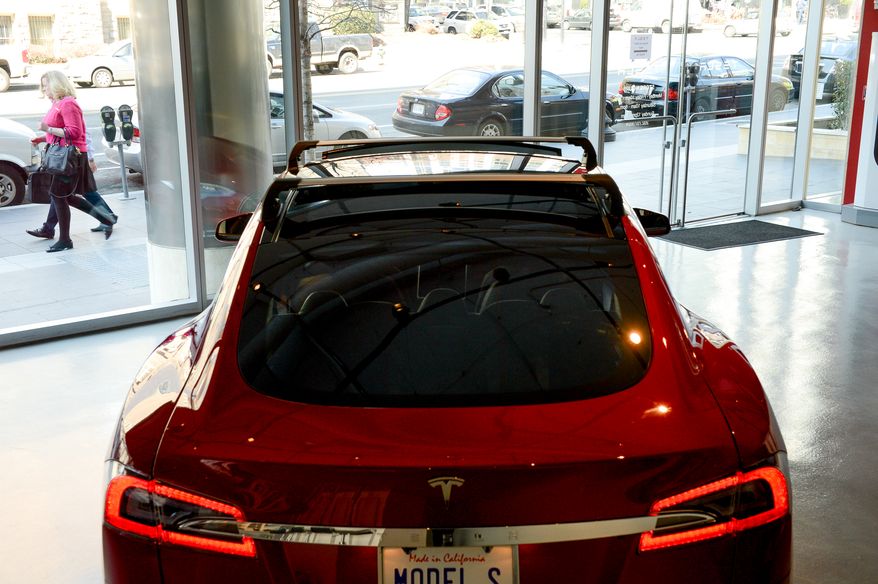 Pedestrians walk by a Tesla Model S in the Tesla Showroom in downtown, Washington, D.C., Thursday, March 20, 2014. (Andrew Harnik/The Washington Times)