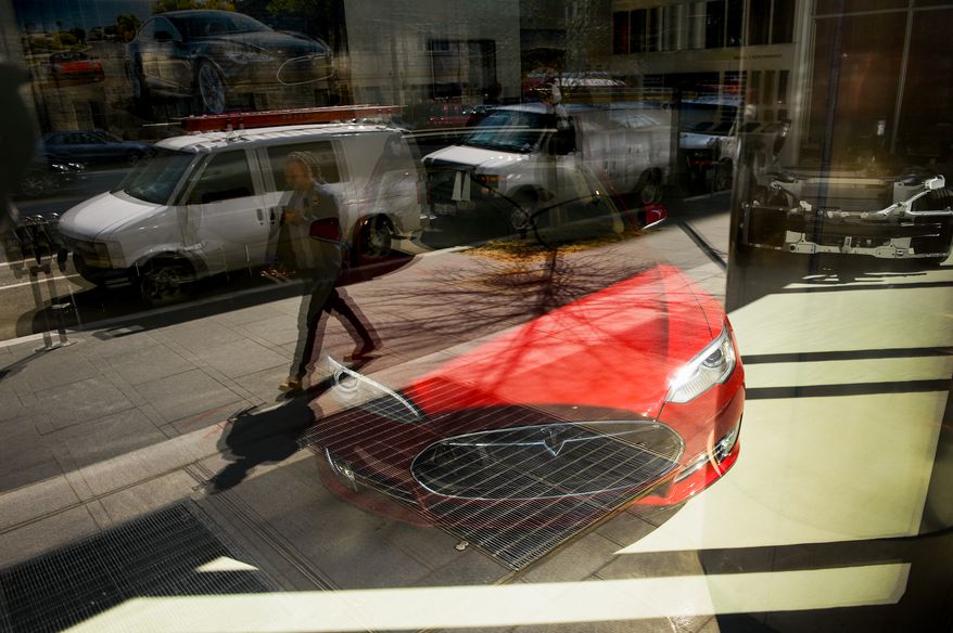 Pedestrians walk past the Tesla Showroom in downtown, Washington, D.C., Thursday, March 20, 2014. (Andrew Harnik/The Washington Times)