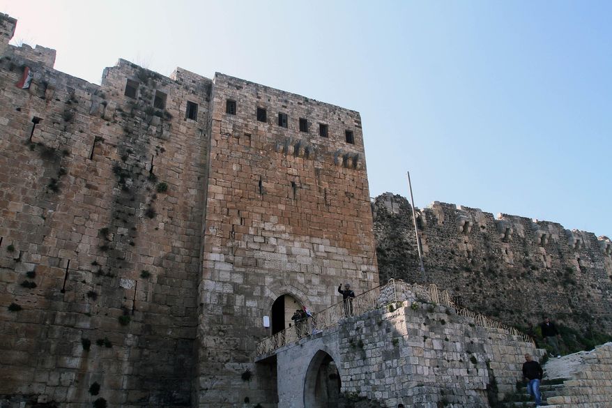 Syrian troops stand by the Crac des Chevaliers as they take reporters on a tour a day after Syrian troops ousted rebels from the castle located near the village of Hosn, Syria, Friday, March 21, 2014. The Syrian army ousted rebels from the massive Crusader fortress after several hours of fierce fighting, killing at least 93 of them as they fled to neighboring Lebanon, an army commander told reporters on a government-led tour of the area Friday. (AP Photo)