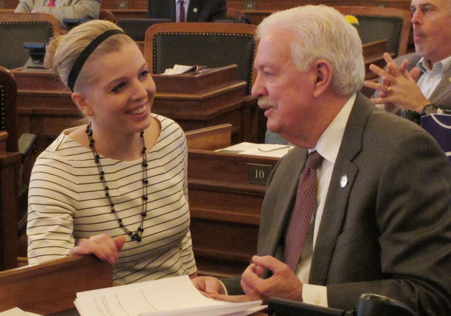 Kansas House Speaker Ray Merrick, right, a Stilwell Republican, confers with his communications director, Rachel Whitten, left, during the chamber's session, Friday, March 21, 2014, at the Statehouse in Topeka, Kan. Merrick says House Republican leaders will draft a new school funding plan devoid of provisions designed to increase the number of charter schools in the state, which were not discussed in negotiations with other lawmakers. (AP Photo/John Hanna)