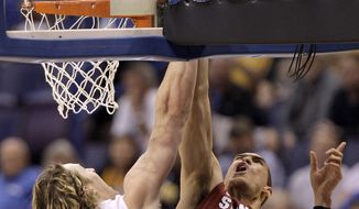 New Mexico&#39;s Cameron Bairstow (41) blocks a shot by Stanford&#39;s Dwight Powell (33) during the first half of a second-round game in the NCAA college basketball tournament, Friday, March 21, 2014, in St. Louis. (AP Photo/Charlie Riedel)