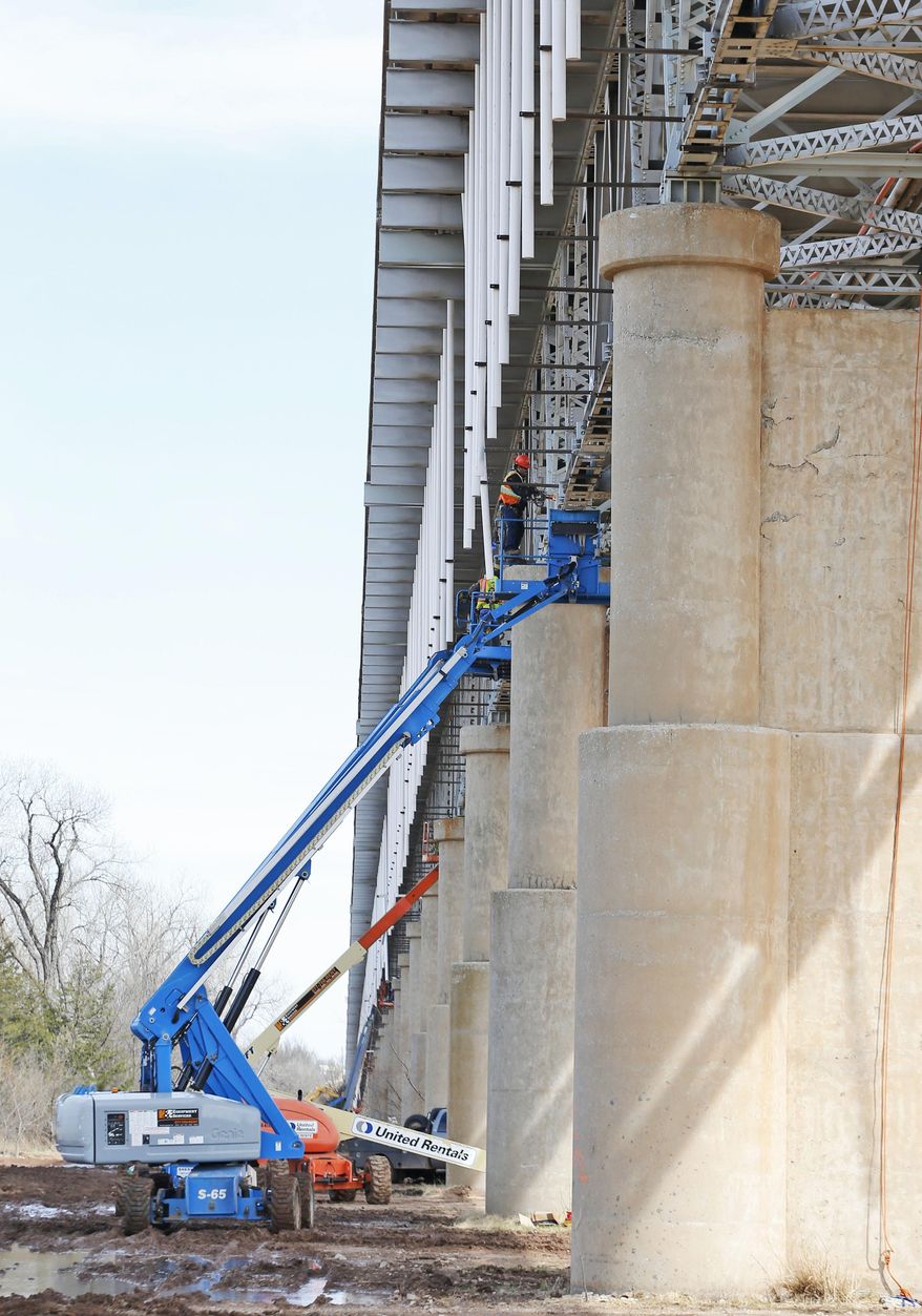 Workers repair the underside of the James C. Nance Memorial Bridge, which links Purcell, Okla. and Lexington, Okla., near Purcell, Okla., Monday, March 17, 2014. Purcell and Lexington are about 4,000 feet apart, but with the bridge closure, travel between the communities requires a 40 mile drive. (AP Photo/Sue Ogrocki)