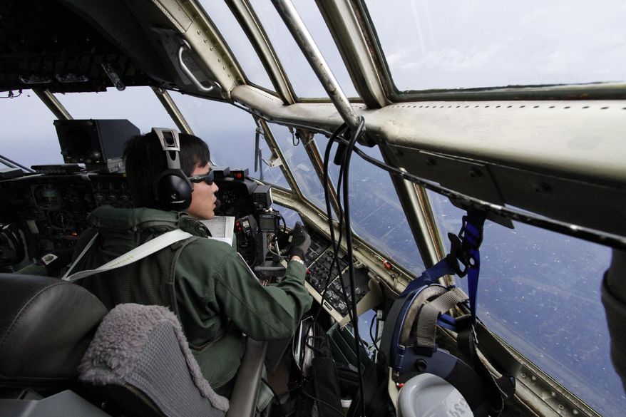 Japanese Air Self-Defense Force copilot Ryutaro Hamahira scans the ocean aboard a C130 aircraft while it flies over the southern search area in the southeastern Indian Ocean, 200 to 300 kilometers (124 to 186 miles) south of Sumatra, Indonesia, Friday, March 21, 2014. Search planes scoured a remote patch of the Indian Ocean but came back empty-handed Friday after looking for any sign of the missing Malaysia Airlines jet, another disappointing day in one of the world's biggest aviation mysteries. (AP Photo/Koji Ueda)