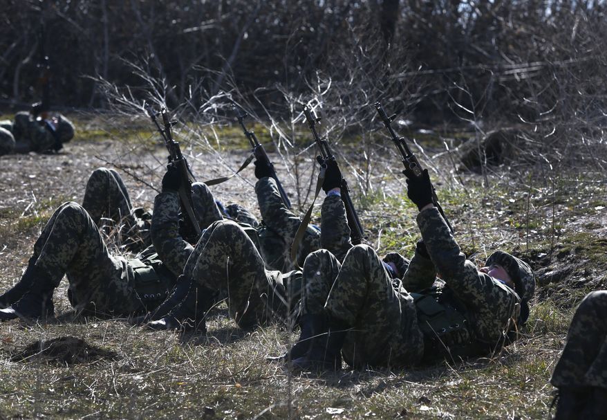 Ukrainian border guards perform an exercise in anti-air attack during training at a military camp in the village of Alekseyevka on the Ukrainian-Russian border, eastern Ukraine, Friday, March 21, 2014. Russian President Vladimir Putin has signed a resolution approved by parliament to annex Crimea. (AP Photo/Sergei Grits)