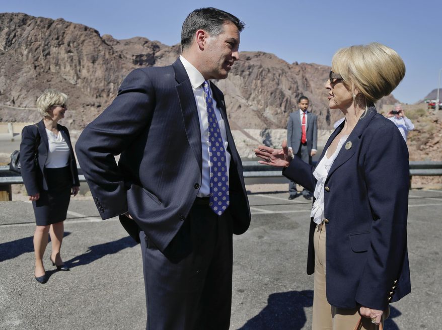 Nevada Gov. Brian Sandoval, left, and Arizona Gov. Jan Brewer talk before a news conference, Friday, March 21, 2014, at Hoover Dam in Arizona. The two governors gathered to unveil signs that will be posted along the proposed Interstate 11. It was a symbolic effort meant to keep up momentum on the project, which is coming of age in an era of scarce highway funding. (AP Photo/Julie Jacobson)