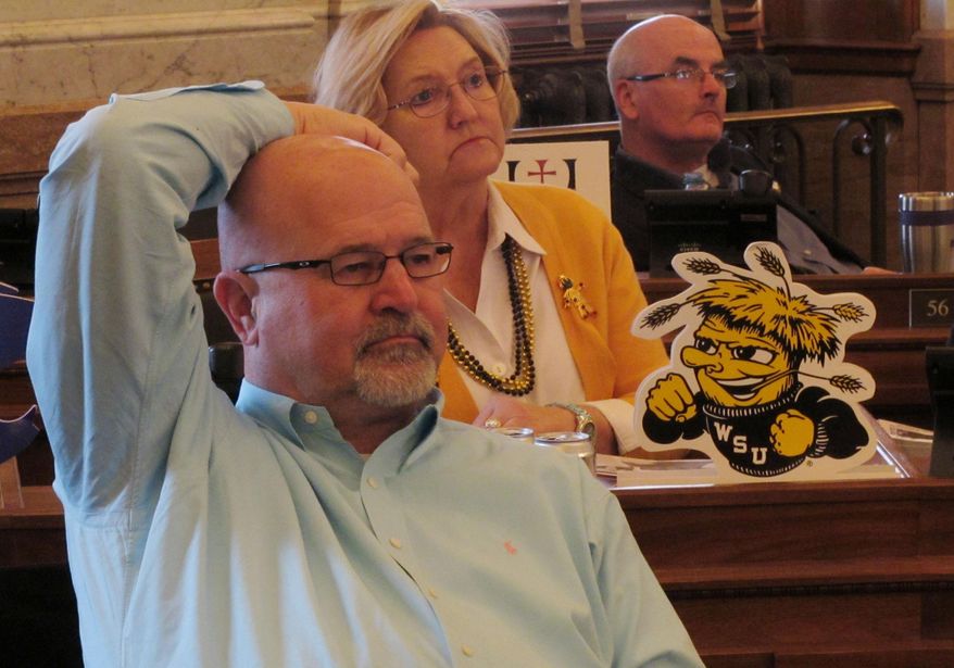 Kansas state Reps. Stan Frownfelter, left, of Kansas City; Carolyn Bridges, center, of Wichita, and Jim Ward, right, of Wichita, follow a House debate on a bill to bring Kansas into a compact with other states seeking to exempt themselves from the federal health care overhaul, Friday, March 21, 2014, at the Statehouse in Topeka, Kan. The three Democrats oppose the measure. (AP Photo/John Hanna)