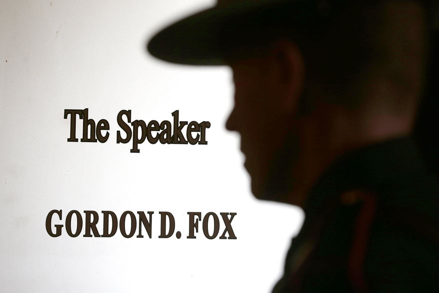 A Rhode Island state police officer stands guard outside the office of the House Speaker Gordon Fox at the Statehouse in Providence, R.I., Friday, March 21, 2014. (AP Photo/Michael Dwyer)