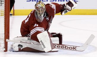 Phoenix Coyotes&#39; Mike Smith looks at the puck after it hit the post during the first period of an NHL hockey game against the Florida Panthers, Thursday, March 20, 2014, in Glendale, Ariz. (AP Photo/Ross D. Franklin)