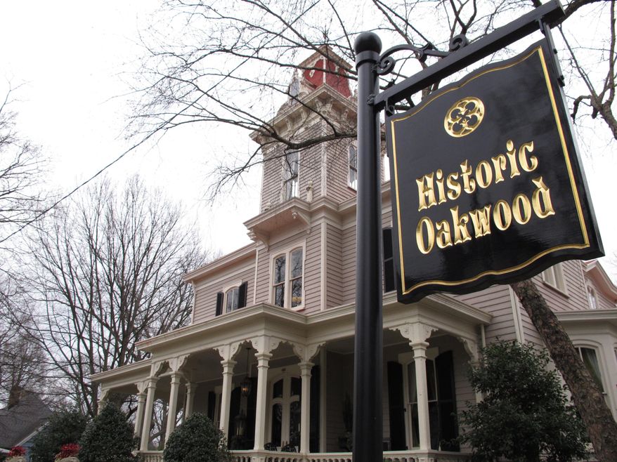 A sign in front of a Victorian home marks the boundary of the Historic Oakwood District in Raleigh, N.C., on Sunday, March 16, 2014. The clash over whether a modern house under construction fits in with its older neighbors is headed to court. (AP Photo/Allen G. Breed)