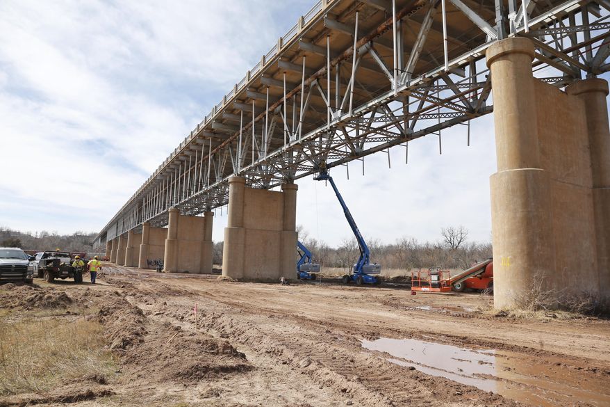 Workers repair the underside of the James C. Nance Memorial Bridge, which links Purcell, Okla. and Lexington, Okla., near Purcell, Okla., Monday, March 17, 2014. Purcell and Lexington are about 4,000 feet apart, but with the bridge closure, travel between the communities requires a 40 mile drive. (AP Photo/Sue Ogrocki)