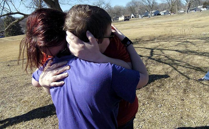 In this Thursday, March 20, 2014 photo, Corbin Crawford, 12, is reunited with his mom, Barbara Crawford, after he and his 7-year-old brother had to be rescued from the ice above the Hydroelectric Dam on the Des Moines River near Fort Dodge, Iowa. The boys got stuck on a sheet of ice about 75 feet from the west bank of the river. (AP Photo/The Messenger, Hans Madsen)