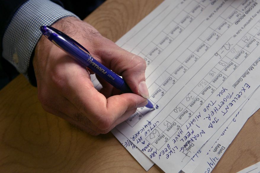 **FILE** Sixth-grade math teacher Justin Kazmark mark report cards with a purple pen at P.S.188 in New York, on April 1, 2005. Kazmark is among teachers who no longer use red pens when marking homework or grading test papers, preferring to use purple. (Associated Press)