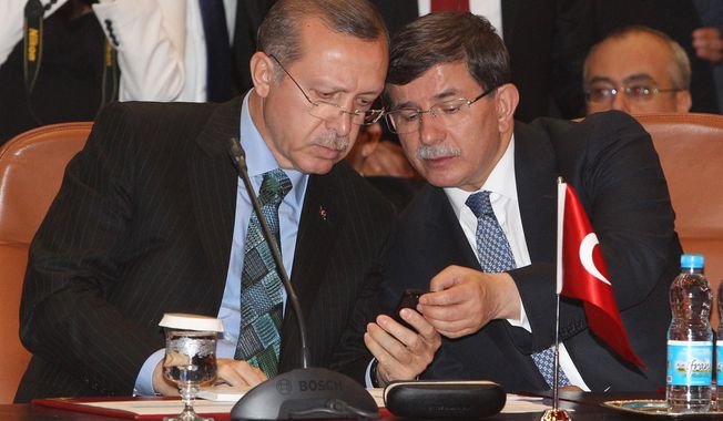 Turkish Prime Minister Recep Tayyip Erdogan, left, and Turkish Foreign Minister Ahmet Davutoglu, right,  look on a cell phone during a meeting  at the  foreign ministry in Rabat, Morocco, Monday, June 3, 2013. On Monday, Erdogan again dismissed the street protests as being organized by extremists, described them as a temporary blip and angrily rejected comparisons with the Arab Spring uprisings. (AP Photo / Abdeljalil Bounhar)
