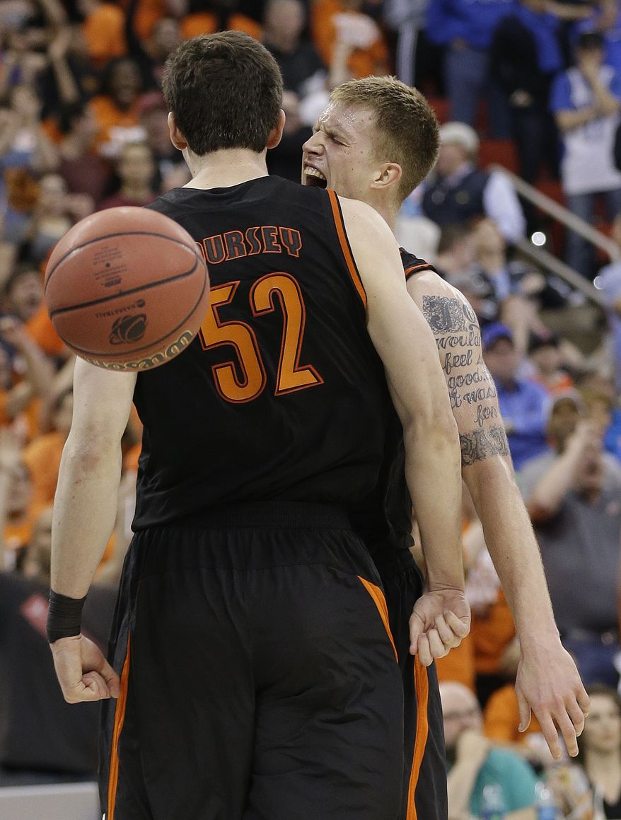 Mercer forward Jakob Gollon celebrates a basket with Mercer forward Daniel Coursey (52) during the second half of an NCAA college basketball second-round game against Duke, Friday, March 21, 2014, in Raleigh, N.C. Mercer won 78-71. (AP Photo/Gerry Broome)