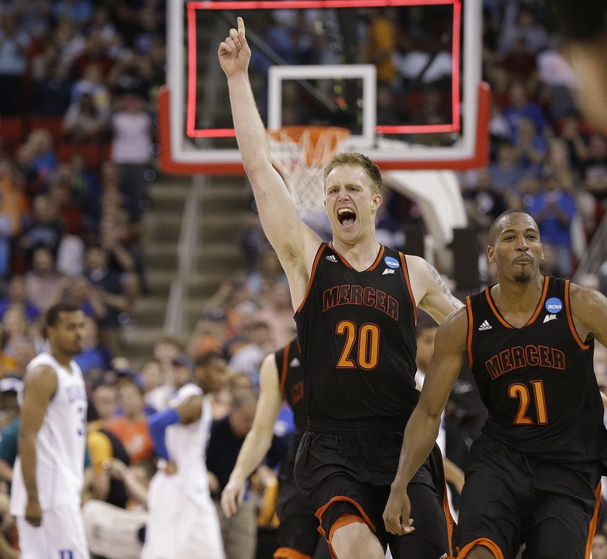 Mercer forward Jakob Gollon (20) and guard Langston Hall (21) celbrate after defeating Duke 78-71 in an NCAA college basketball second-round game against Duke, Friday, March 21, 2014, in Raleigh, N.C.(AP Photo/Gerry Broome)