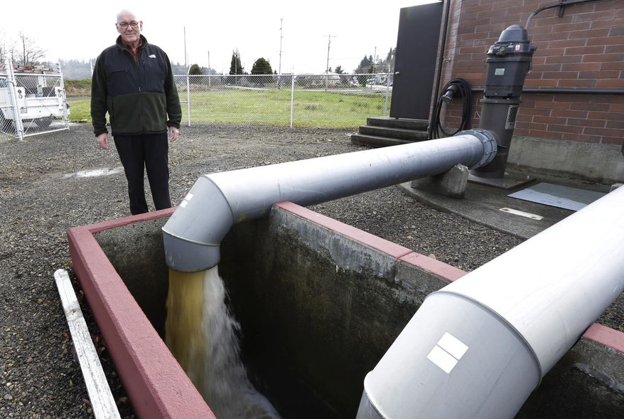 ADVANCE FOR USE MONDAY, MARCH 24, 2014 AT 3 A.M. AND THEREAFTER - Jack Durney, mayor of Hoquiam, Wash., stands Monday, March 18, 2014 next to a pump that takes groundwater away from neighborhoods in his town, most of which is located on a flood plain. Durney says possible increases in federal flood insurance rates would adversely affect many who live in Hoquiam. (AP Photo/Ted S. Warren)