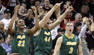 Players on the North Dakota State bench stand and cheer as their team takes the lead against Oklahoma in overtime during a second-round game of the NCAA men&#39;s college basketball tournament in Spokane, Wash., Thursday, March 20, 2014. North Dakota State won 80-75 in overtime. (AP Photo/Elaine Thompson)