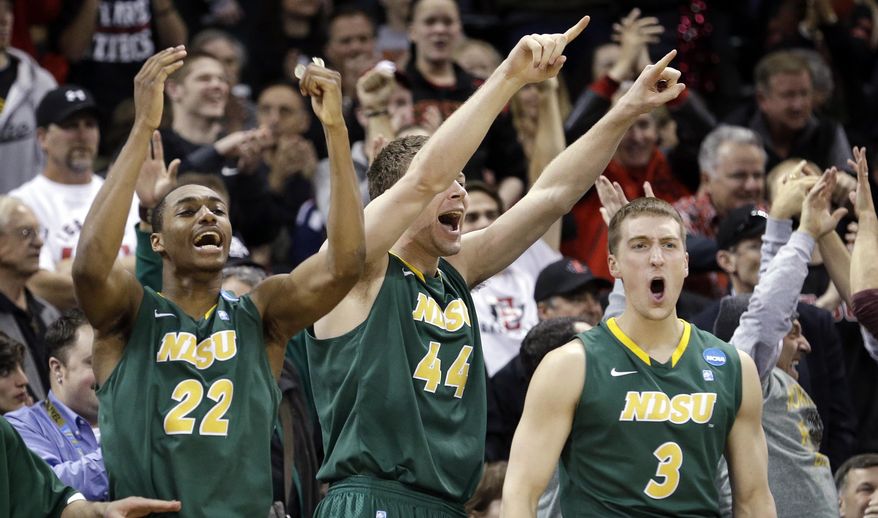 Players on the North Dakota State bench stand and cheer as their team takes the lead against Oklahoma in overtime during a second-round game of the NCAA men's college basketball tournament in Spokane, Wash., Thursday, March 20, 2014. North Dakota State won 80-75 in overtime. (AP Photo/Elaine Thompson)