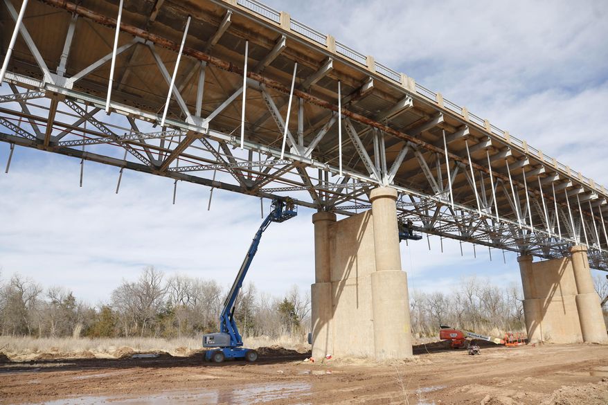 Workers repair the underside of the James C. Nance Memorial Bridge, which links Purcell, Okla. and Lexington, Okla., near Purcell, Okla., Monday, March 17, 2014. Purcell and Lexington are about 4,000 feet apart, but with the bridge closure, travel between the communities requires a 40 mile drive. (AP Photo/Sue Ogrocki)