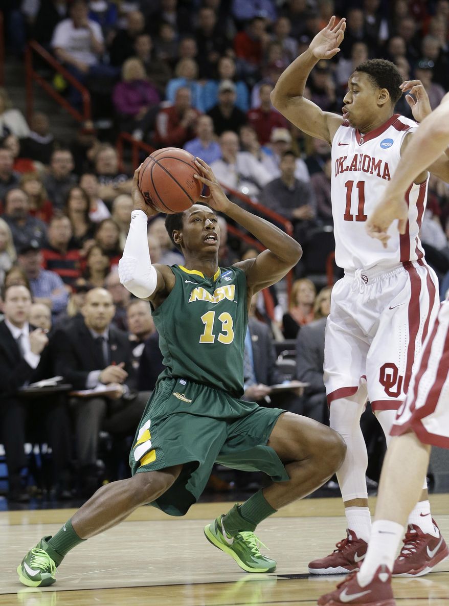 North Dakota State's Carlin Dupree (13) looks for a shot as Oklahoma's Isaiah Cousins defends in overtime during a second-round game of the NCAA men's college basketball tournament in Spokane, Wash., Thursday, March 20, 2014. North Dakota State won 80-75 in overtime. (AP Photo/Elaine Thompson)