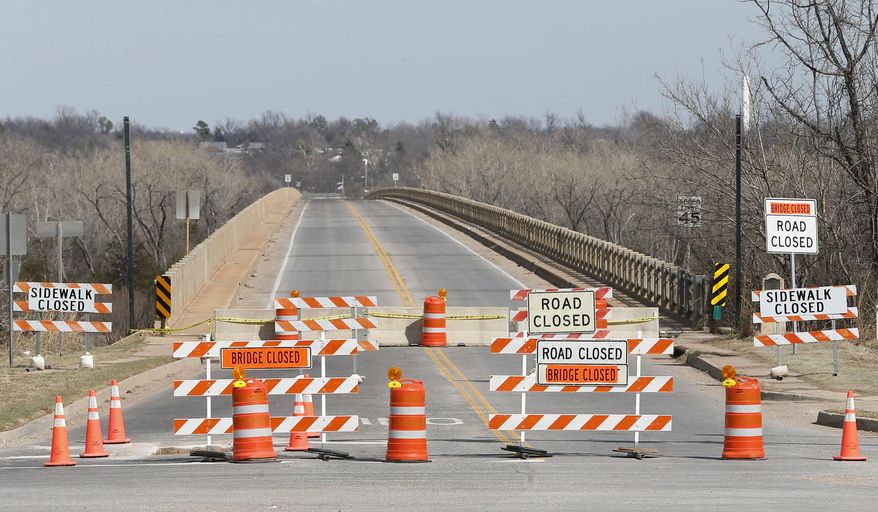 Workers repair the underside of the James C. Nance Memorial Bridge, which links Purcell, Okla. and Lexington, Okla., near Purcell, Okla., Monday, March 17, 2014. Purcell and Lexington are about 4,000 feet apart, but with the bridge closure, travel between the communities requires a 40 mile drive. (AP Photo/Sue Ogrocki)