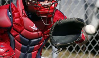 ADVANCE FOR WEEKEND EDITIONS, MARCH 22-23 - FILE - In this Feb. 17, 2014, file photo, Washington Nationals catcher Jose Lobaton catches the ball during a spring training baseball workout,in Viera, Fla. In a sabermetric age where everything is measurable, teams can calculate how many runs a catcher can save by mastering the art of pitch framing. This spring training, nationals general manager Mike Rizzo Rizzo made a trade with the Tampa Bay Rays to acquire Lobaton, in part because Lobaton rated well in pitch-framing. (AP Photo/Alex Brandon, File)
