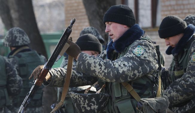 Ukrainian border guards prepare for training at a military camp in the village of Alekseyevka on the Ukrainian-Russian border, eastern Ukraine, Friday, March 21, 2014. Russian President Vladimir Putin has signed a resolution approved by parliament to annex Crimea. (AP Photo/Sergei Grits)