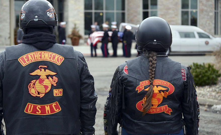 United States Marine Corps veteran Bob Lynch, left, with wife Sherrie, of Chatham, Ill., stand at attention as the flag-draped coffin of Capt. Reid Nannen is placed into a hearse following services at Eastview Christian Church in Bloomington, Ill., Saturday, March 22, 2014. Nannen, of Hopedale, Ill., died March 1 when his jet crashed during a training exercise in Nevada. (AP Photo/The Pantagraph, Steve Smedley)
