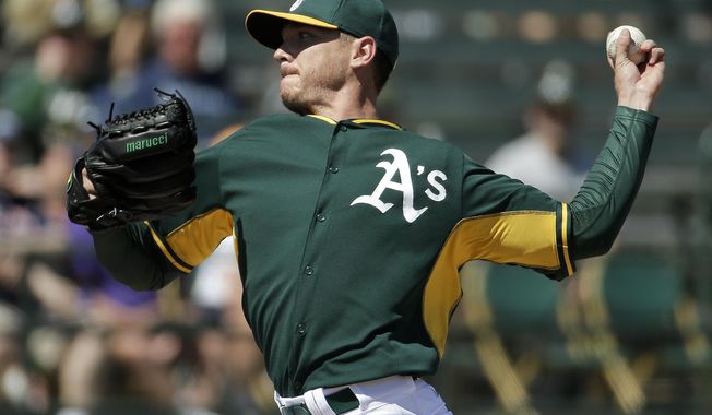 Oakland Athletics starting pitcher Scott Kazmir throws to the Seattle Mariners during the first inning of a spring exhibition baseball game in Phoenix, Saturday, March 22, 2014. (AP Photo/Chris Carlson)