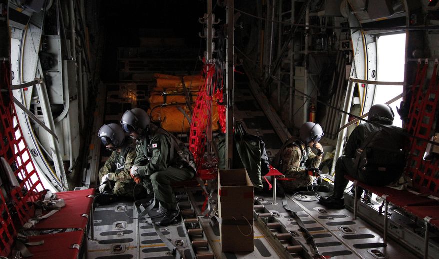 Japanese Air Self-Defense Force loadmasters and trained spotters scan the ocean aboard a C130 aircraft while it flies over the southern search area in the southeastern Indian Ocean, 200 to 300 kilometers (124 to 186 miles) south of Sumatra, Indonesia, Friday, March 21, 2014. Search planes scoured a remote patch of the Indian Ocean but came back empty-handed Friday after looking for any sign of the missing Malaysia Airlines jet, another disappointing day in one of the world's biggest aviation mysteries. (AP Photo/Koji Ueda)