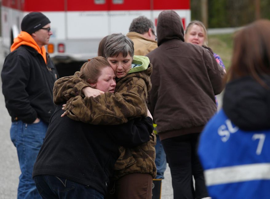 Neighbors gather at the Oso Fire Department to look for updates about the fatal mudslide that washed over homes and over Highway 530 east of Oso, Wash., Saturday, March 22, 2014. Highway 530 was closed in both directions, and authorities confirmed at least two fatalities by Saturday afternoon. (AP Photo /The Daily Herald, Annie Mulligan)