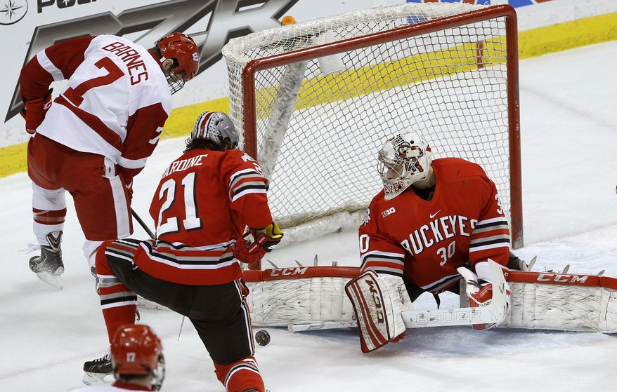 Ohio State goalie Christian Frey (30) deflects a shot by Wisconsin forward Tyler Barnes (7) in front of Ohio State defenseman Sam Jardine (21) during the first period of an NCAA college hockey game for the championship of the Big 10 Conference tournament in St. Paul, Minn., Saturday, March 22, 2014. (AP Photo/Ann Heisenfelt)