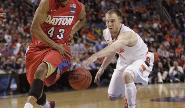 Syracuse&#x27;s Trevor Cooney (10) knocks the ball away from Dayton&#x27;s Vee Sanford (43) during the first half of a third-round game in the NCAA men&#x27;s college basketball tournament in Buffalo, N.Y., Saturday, March 22, 2014. (AP Photo/Bill Wippert)