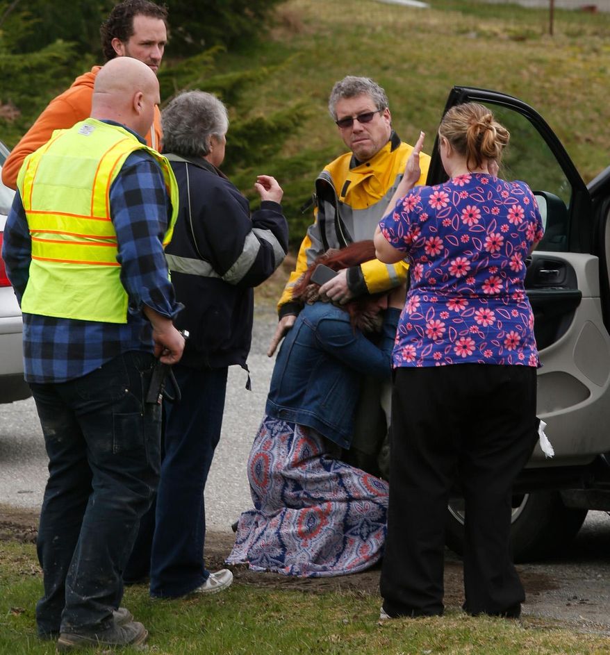 A woman collapses near the Oso Fire Department as neighbors look for news regarding the fatal mudslide that washed over homes and over Highway 530 east of Oso, Wash., Saturday, March 22, 2014. Highway 530 was closed in both directions, and authorities confirmed at least 2 fatalities by Saturday afternoon. (AP Photo /The Daily Herald, Annie Mulligan)