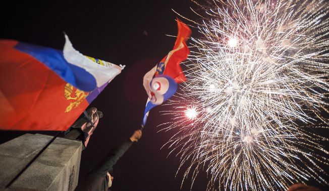 People watch fireworks at the central Nakhimov square in Sevastopol, Crimea, on Friday, March 21, 2014.  Russian President Vladimir Putin completed the annexation of Crimea on Friday, signing a law making the Black Sea peninsula part of Russia. (AP Photo/Andrew Lubimov)