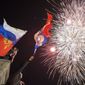 People watch fireworks at the central Nakhimov square in Sevastopol, Crimea, on Friday, March 21, 2014.  Russian President Vladimir Putin completed the annexation of Crimea on Friday, signing a law making the Black Sea peninsula part of Russia. (AP Photo/Andrew Lubimov)