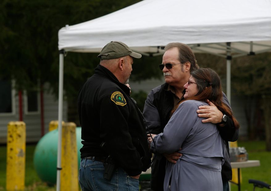 Neighbors gather at the Oso Fire Department looking for updates about the mudslide that washed over homes and over Highway 530 east of Oso, Wash., Saturday, March 22, 2014. Highway 530 was closed in both directions, and authorities confirmed at least 2 fatalities by Saturday afternoon. (AP Photo /The Daily Herald, Annie Mulligan)