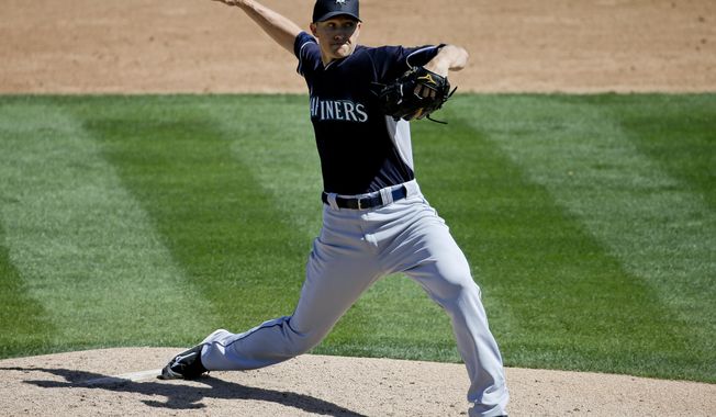 Seattle Mariners starting pitcher Scott Baker throws to the Oakland Athletics during the third inning of a spring exhibition baseball game in Phoenix, Saturday, March 22, 2014. (AP Photo/Chris Carlson)