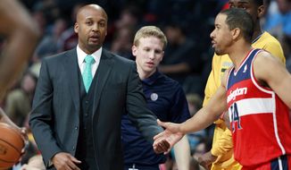 Denver Nuggets head coach Brian Shaw, left, greets Washington Wizards guard Andre Miller as he takes floor in the first quarter of an NBA basketball game on Sunday, March 23, 2014, in Denver. Shaw and Miller argued over playing time for Miller during a game on New Year&#x27;s Day, which ended up in Miller being traded to Washington. (AP Photo/David Zalubowski)