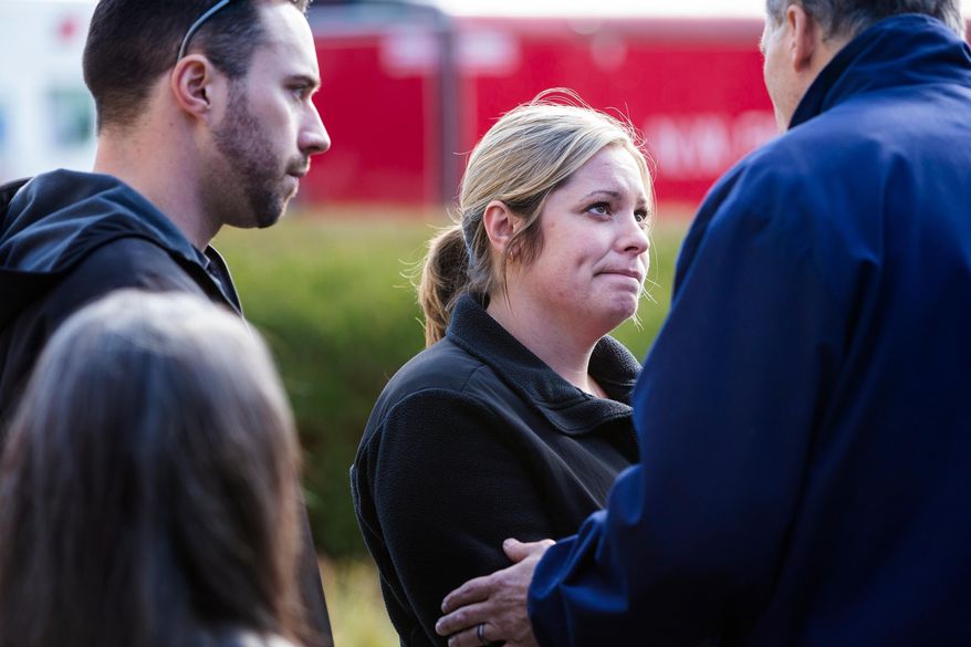Snohomish County residents affected by the mudslide are comforted by Gov. Jay Inslee, right, following a media availability segment, Sunday, March 23, 2014, outside of the Arlington Police Department in Arlington, Wash. Rescue crews searched into the night for survivors from a massive mudslide in Washington state that killed at least three people, after hearing voices from the debris field pleading for help. (AP Photo/seattlepi.com, Jordan Stead)