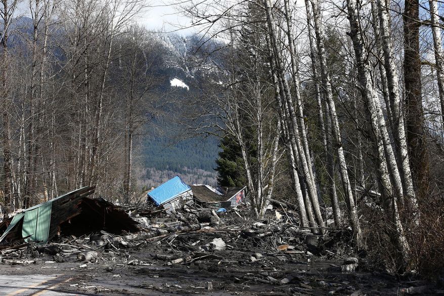 A demolished house sits in the mud on Highway 530, Sunday, March 23, 2014 the day after a giant landslide occurred near Oso, Wash. The slide of mud, trees and rocks happened about 11 a.m. Saturday morning. Several people - including an infant - were critically injured and at least six houses were destroyed. (AP Photo/The Seattle Times, Lindsey Wasson, Pool)