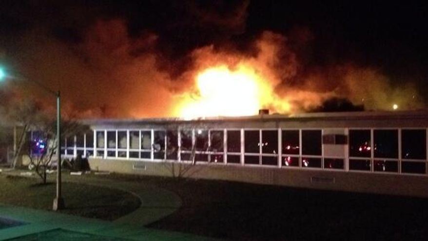 Flames rise at James Monroe School in Edison Township, N.J., Saturday, March 22, 2014. District officials met Sunday afternoon to develop a plan for the affected children. Dozens of firefighters battled the blaze, no residents were injured. Officials say roughly 500 kindergarten through fifth-grade students attended the single-story school, which was celebrating its 50th anniversary this year. (AP Photo/Home News Tribune, Suzanne Russell) NEWARK OUT; NO SALES; NEWARK STAR LEDGER OUT